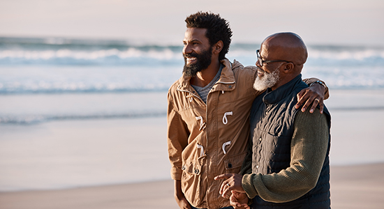 Father and adult son on beach