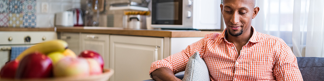 Man sitting on sofa looking at laptop